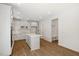 Bright kitchen features white cabinets, a large island, stainless steel appliances, and hardwood floors at 1229 Dimaggio Dr # 8, Raleigh, NC 27616
