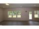 Living area with wood-look flooring, three windows, and glass patio door to the backyard at 1229 Dimaggio Dr # 8, Raleigh, NC 27616