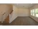 Open living area with staircase, hardwood floors, recessed lights, and bright windows with a view of the yard at 1229 Dimaggio Dr # 8, Raleigh, NC 27616