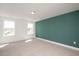 Bright carpeted bedroom features a green accent wall and two windows at 1250 Barreto Dr, Wendell, NC 27591
