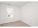 Neutral carpeted bedroom features a single window with a view of the adjacent home at 1250 Barreto Dr, Wendell, NC 27591