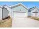 Attached two-car garage with white door and light blue siding, complemented by a spacious concrete driveway at 1250 Barreto Dr, Wendell, NC 27591
