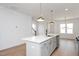 Stylish kitchen island with pendant lighting and stainless steel appliances overlooks the living space at 1250 Barreto Dr, Wendell, NC 27591