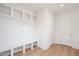 Bright mudroom features white cabinets, storage, bench, coat hooks, and wood-look tile flooring at 1250 Barreto Dr, Wendell, NC 27591