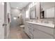 Bathroom with gray tile, double sink vanity, and frameless glass shower at 1311 Arena Ln, Fuquay Varina, NC 27526
