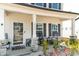 Close-up of the welcoming front porch area with seating and decorative plants and stonework at 1311 Arena Ln, Fuquay Varina, NC 27526