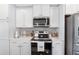 Well-lit kitchen featuring white cabinetry, stainless steel appliances, and modern countertops at 1311 Arena Ln, Fuquay Varina, NC 27526
