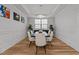 Bright dining room with white wainscoting, hardwood floors, and decorative chandelier at 1403 Medici Ct, Cary, NC 27518