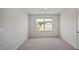 Bright bedroom featuring a large window with natural light and neutral walls and carpet at 156 Paper Birch Way, Fuquay Varina, NC 27526