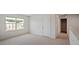 Bright bedroom with large window, neutral walls, plush carpet, and closet door at 156 Paper Birch Way, Fuquay Varina, NC 27526