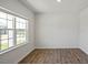 Sunlit bedroom featuring wood flooring, a large window, and neutral paint, creating a cozy atmosphere at 156 Paper Birch Way, Fuquay Varina, NC 27526