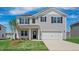 Charming two-story home featuring a two-car garage, landscaped yard, and a welcoming entrance at 156 Paper Birch Way, Fuquay Varina, NC 27526