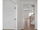 Hallway featuring hardwood floors, white walls, and doorways leading to various rooms in the house at 156 Paper Birch Way, Fuquay Varina, NC 27526