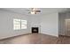 Living room with fireplace and a view of the backyard, ceiling fan and window at 156 Paper Birch Way, Fuquay Varina, NC 27526