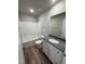 Bathroom featuring a single sink vanity with granite top, a shower-tub combo, and wood-look vinyl floors at 175 Magnolia Run Way, Benson, NC 27504