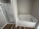 Bathroom features walk-in shower with glass doors, a soaking tub and wood-look floors at 175 Magnolia Run Way, Benson, NC 27504