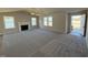 Spacious living room with a fireplace, ceiling fan, plush gray carpet, and large windows offering ample natural light at 175 Magnolia Run Way, Benson, NC 27504