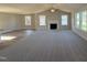 Spacious living room with a fireplace, ceiling fan, plush gray carpet, and large windows offering ample natural light at 175 Magnolia Run Way, Benson, NC 27504