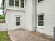 Side view of patio featuring white brick walls, door, and black drain pipe at 206 Ellington Rd, Graham, NC 27253