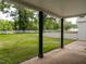 Spacious back porch with gray concrete, black columns, and a view of the large lawn at 206 Ellington Rd, Graham, NC 27253
