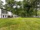 Backyard view of a white brick home with large lawn and many trees surrounding property at 206 Ellington Rd, Graham, NC 27253