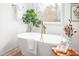 Bright bathroom featuring a modern tub next to a window, complemented by elegant decor and wood-look flooring at 206 Ellington Rd, Graham, NC 27253