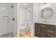 Bright bathroom features a glass shower, modern vanity, and round mirror at 206 Ellington Rd, Graham, NC 27253