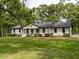 Alluring one-story home with white brick, dark trim, fresh landscaping, and black roof at 206 Ellington Rd, Graham, NC 27253