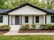 Charming entrance with a gray front door, modern pillars, fresh landscaping and concrete steps at 206 Ellington Rd, Graham, NC 27253
