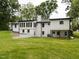 Backyard view of a two story white brick home, with large lawn, and ample lighting at 206 Ellington Rd, Graham, NC 27253