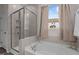 Relaxing bathroom features a soaking tub with a shower, neutral tile, and bright natural light at 25 Bourne Dr, Franklinton, NC 27525