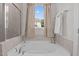 Relaxing bathroom features a soaking tub with a shower, neutral tile, and bright natural light at 25 Bourne Dr, Franklinton, NC 27525