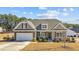 Charming home featuring stone accents, attached two-car garage, and covered front porch with inviting bench seating at 25 Bourne Dr, Franklinton, NC 27525