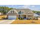 Charming home featuring a stone-accented facade, manicured lawn, and welcoming front porch at 25 Bourne Dr, Franklinton, NC 27525