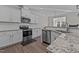 Bright kitchen boasts stainless appliances, granite countertops, white cabinetry, and wood flooring at 25 Bourne Dr, Franklinton, NC 27525