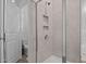 Modern shower features neutral tile, glass doors, and convenient built-in shelving for storage at 25 Bourne Dr, Franklinton, NC 27525