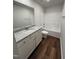 A well-lit bathroom featuring a modern vanity, granite countertop, wood-look flooring, and shower-tub combination at 275 Magnolia Run Way, Benson, NC 27504