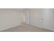 Carpeted bedroom featuring neutral decor and two doors at 276 Hanging Elm Ln, Fuquay Varina, NC 27526