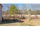 The private backyard features mature trees, a black fence, and grassy areas at 2933 Elmfield St, Raleigh, NC 27614
