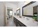 Primary bathroom with double sinks, granite counters, dark cabinets, and decorative mirrors at 2933 Elmfield St, Raleigh, NC 27614