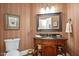 Charming powder room with a dark vanity, decorative mirror, and patterned wallpaper at 2933 Elmfield St, Raleigh, NC 27614