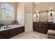 Bright primary bathroom featuring double sinks, a separate glass shower, and a soaking tub beneath an arched window at 2933 Elmfield St, Raleigh, NC 27614