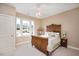 Cozy bedroom with a vintage-style bed frame, decorative ceiling fan, and large window at 2933 Elmfield St, Raleigh, NC 27614