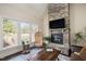 Comfortable living room featuring a stone fireplace, vaulted ceiling, and large windows providing natural light at 2933 Elmfield St, Raleigh, NC 27614