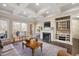 Bright living room features a fireplace, custom built-ins, coffered ceilings, and views of the backyard at 2933 Elmfield St, Raleigh, NC 27614