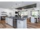Stylish kitchen with white cabinets, stainless steel appliances, a dark island and hardwood floors at 294 Arcadius Dr, Clayton, NC 27520