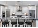 Elegant kitchen featuring an island with seating, stainless appliances, white cabinets and stylish lighting at 294 Arcadius Dr, Clayton, NC 27520