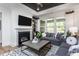 Cozy living room featuring a fireplace, modern decor, a gray sofa, and ample natural light at 294 Arcadius Dr, Clayton, NC 27520