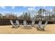 Grassy backyard featuring a fire pit surrounded by Adirondack chairs and a wooden fence at 3012 Freeman Farm Way, Rolesville, NC 27571