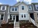 Charming multi-tone townhome featuring stone accents, stairs leading to the entrance and beautifully landscaped yard at 314 Church St # 37, Wendell, NC 27591